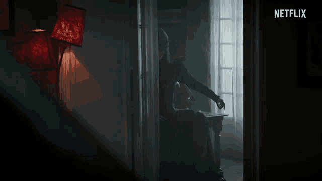 a person sitting in a dark room with a netflix logo in the corner