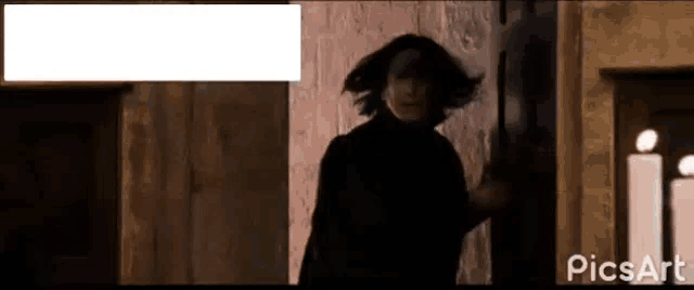 a man in a black coat is standing in a doorway .