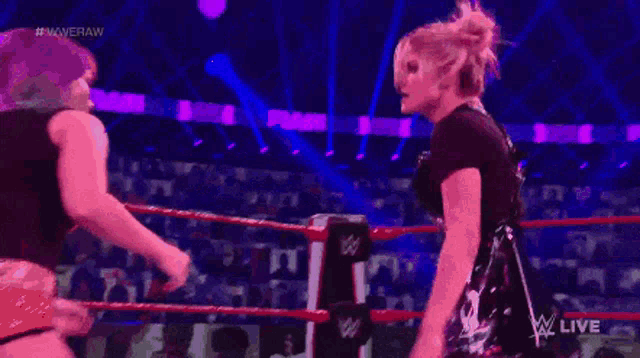 two women are wrestling in a ring with a referee and the words #wweraw on the bottom
