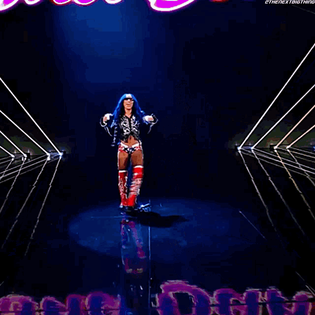 a woman with blue hair is standing on a stage with her hands on her head