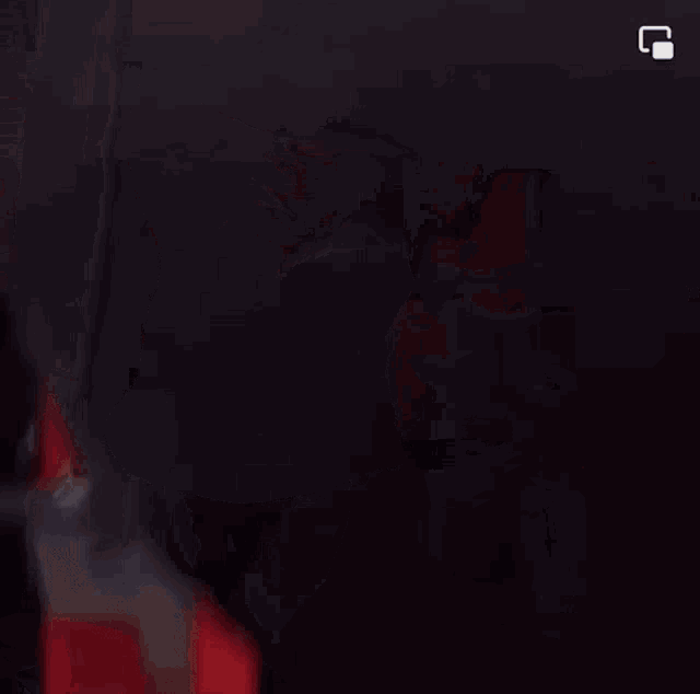 a woman is punching a punching bag in a gym in front of a red wall .
