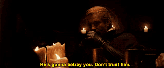 a man in a dark room with candles says he 's gonna betray you