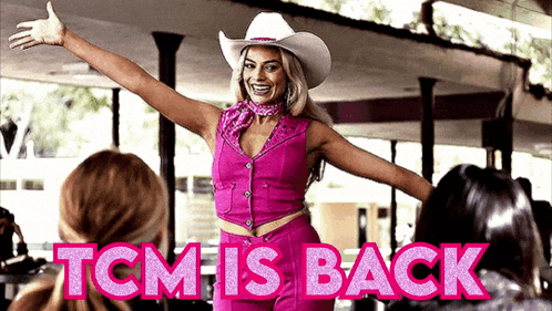 a woman in a cowboy hat is standing in front of a sign that says " tcm is back "