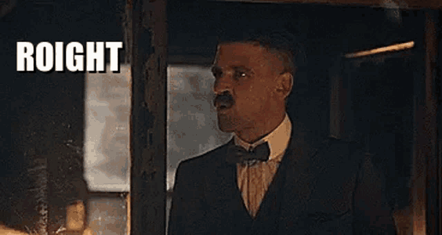 a man in a suit and bow tie is standing in front of a window with the word roight written on it .