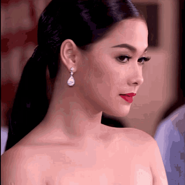 a close up of a woman 's face wearing earrings