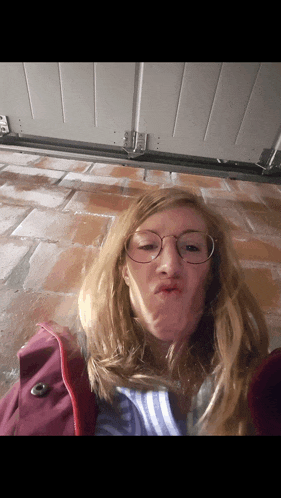 a woman wearing glasses is making a funny face