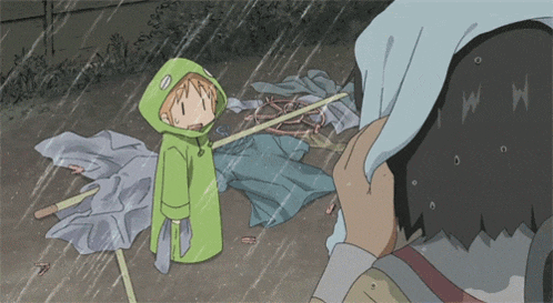 a boy in a green hooded jacket is holding an umbrella