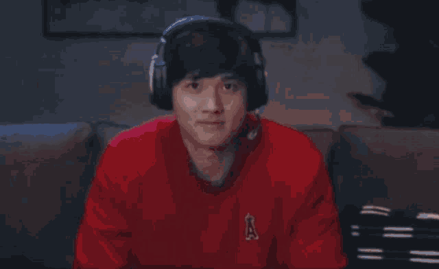 a man wearing headphones and a red sweater with an a on it