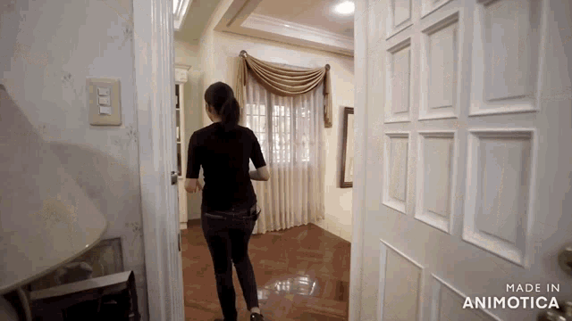 a woman is walking through a doorway with the words made in animatica on the bottom right