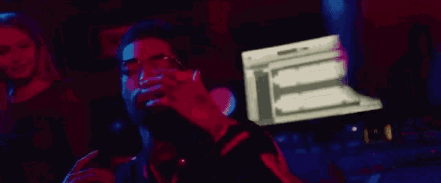 a man is sitting in front of a computer in a dark room .