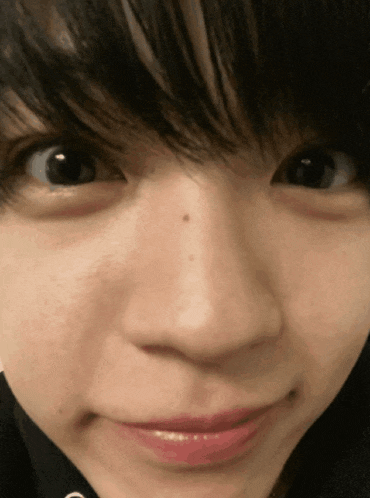 a close up of a person 's face with a small spot on their nose