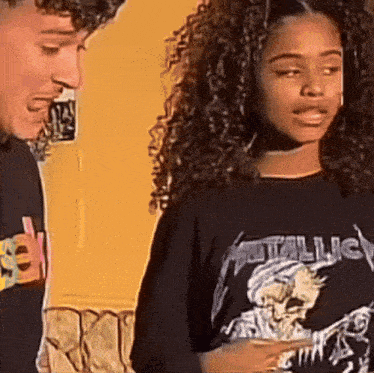 a woman wearing a metallica t-shirt stands next to a man