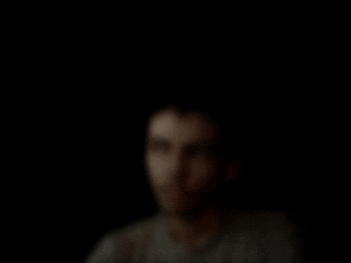 a blurred image of a man 's face in the dark