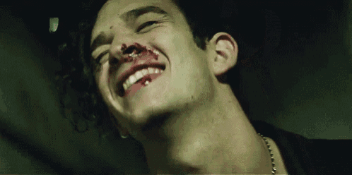 a close up of a man 's face with blood on it .