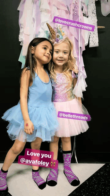 two little girls standing next to each other with purple stickers that say love crushcrowns