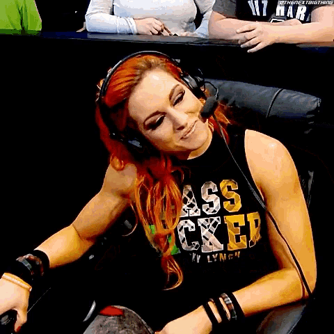 a woman wearing headphones and a black shirt that says ass locked