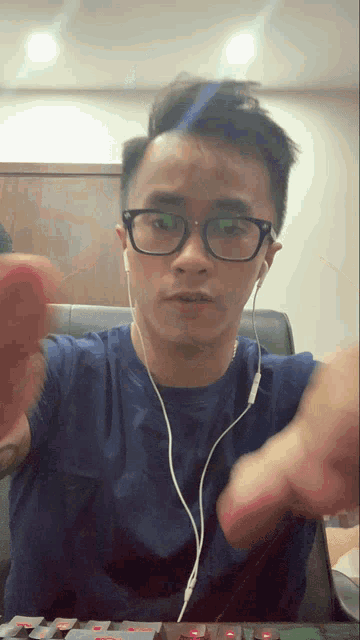 a man wearing glasses and earbuds is playing a keyboard