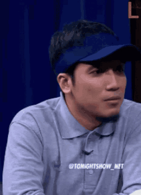 a man wearing a blue hat and a shirt that says tonightsshow_net
