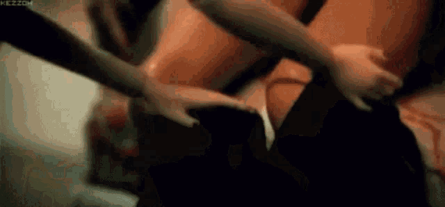 a man and a woman are having sex on a bed and the woman is holding the man 's butt .