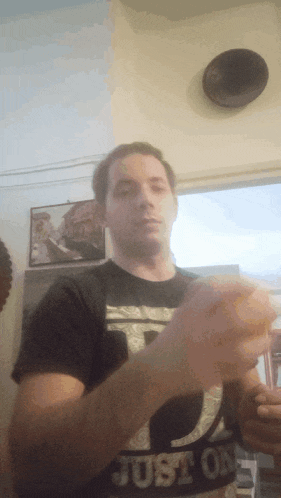 a man wearing a boston shirt holds something in his hands