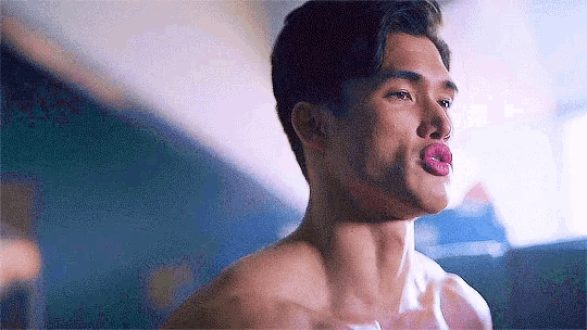a man without a shirt is sticking his tongue out .