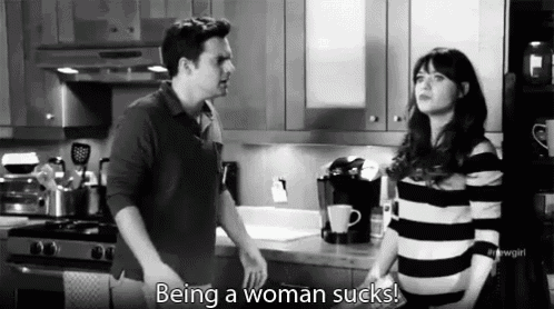 a black and white photo of a man and woman in a kitchen with the caption being a woman sucks ..