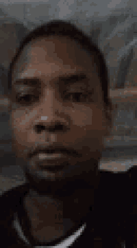 a close up of a man 's face in a black shirt .