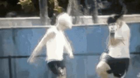 two men are playing soccer in a pool .