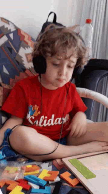a little boy wearing headphones and a red shirt that says " salidas "