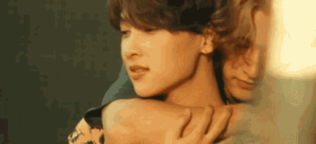 a man and a woman are hugging each other and looking at each other .