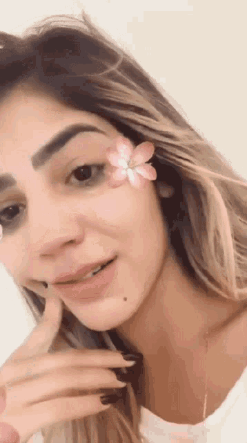 a close up of a woman with a flower on her forehead