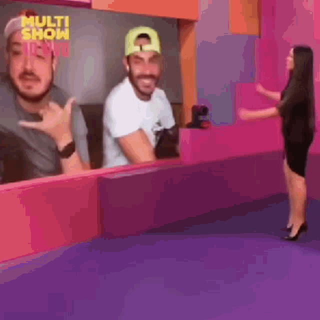 a woman is standing in front of a mirror with a picture of a man and a woman on it .