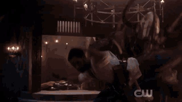 a man in a white shirt is being thrown in the air with a cw logo in the corner