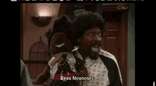 a man and a woman are sitting next to each other in a living room . the man is holding a stuffed animal .