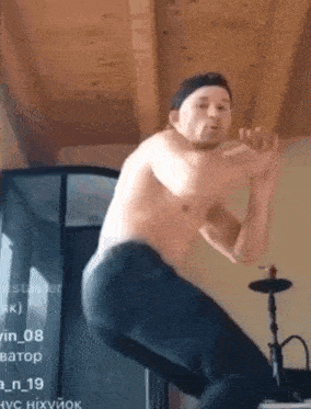 a shirtless man is jumping in the air in a room with a hookah .