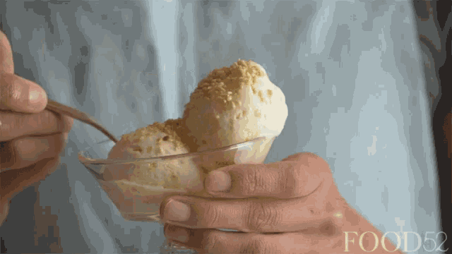 a person is scooping ice cream from a bowl with food52 written on the bottom
