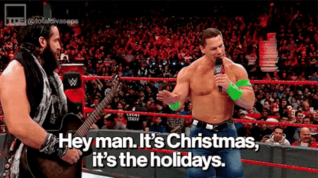 a wrestler is talking into a microphone while another wrestler plays a guitar in a ring .