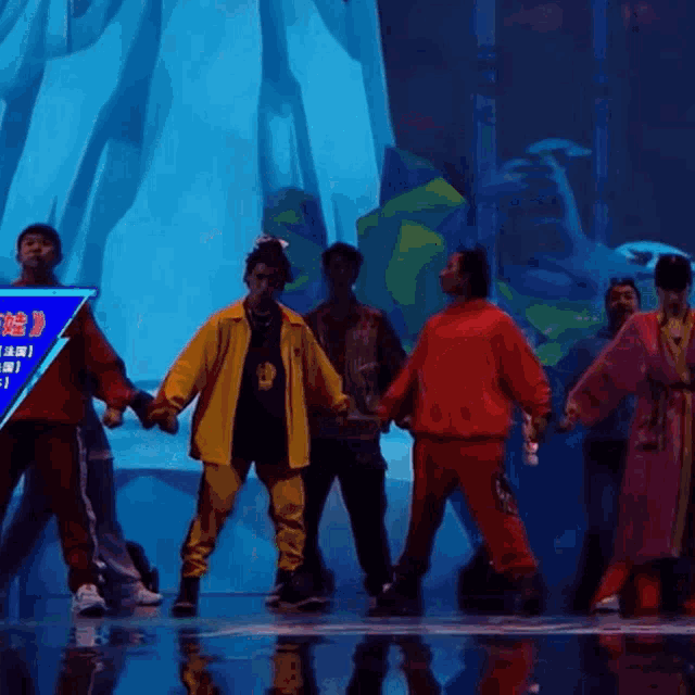 a group of people are dancing in front of a blue sign that says ' a ' on it