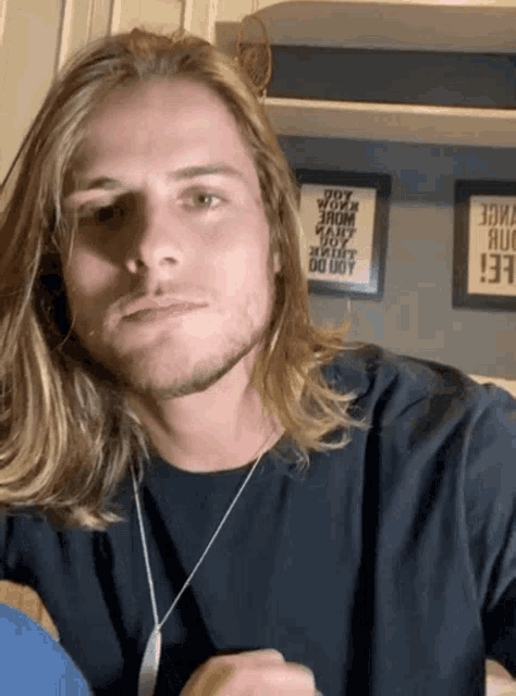 a man with long blonde hair and a beard wearing a black shirt