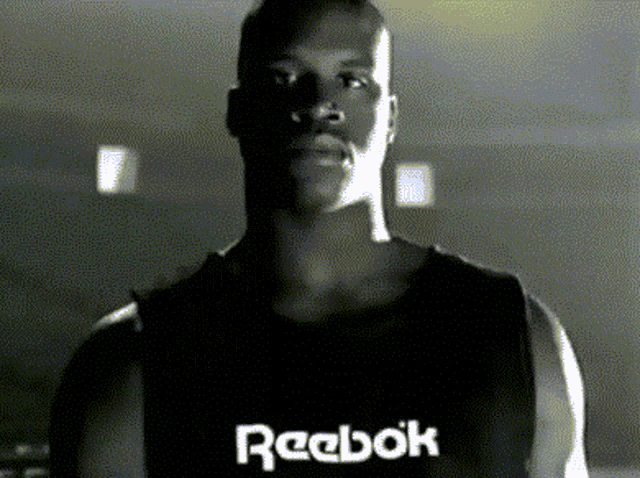 a man wearing a black reebok tank top