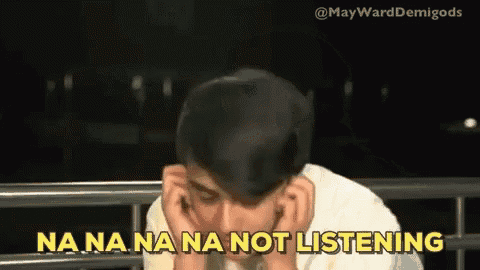 a man is covering his ears with his hands and says na na na na not listening .