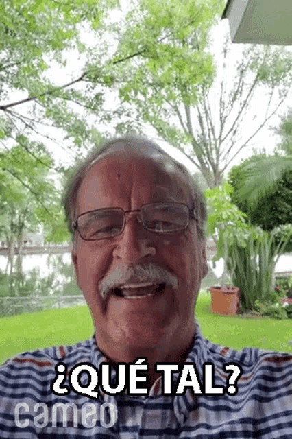 an older man with glasses and a mustache is smiling and says que tal ?