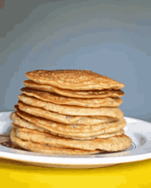 a stack of pancakes sits on a white plate