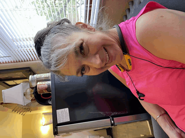 a woman wearing a pink shirt that says dewalt on the neck