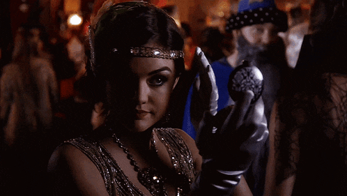 a woman in a headband and gloves is looking at herself in a mirror