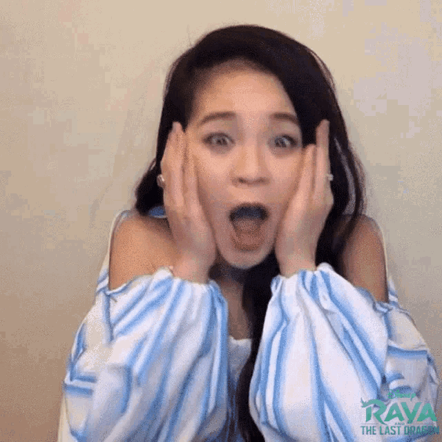 a woman with a surprised look on her face is wearing a blue and white striped shirt that says raya the last dragon