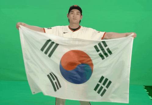 a man in a nike jersey holds a korean flag in front of a green screen