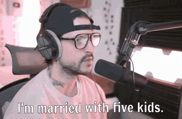 a man wearing headphones and glasses is talking into a microphone and says i 'm married with five kids