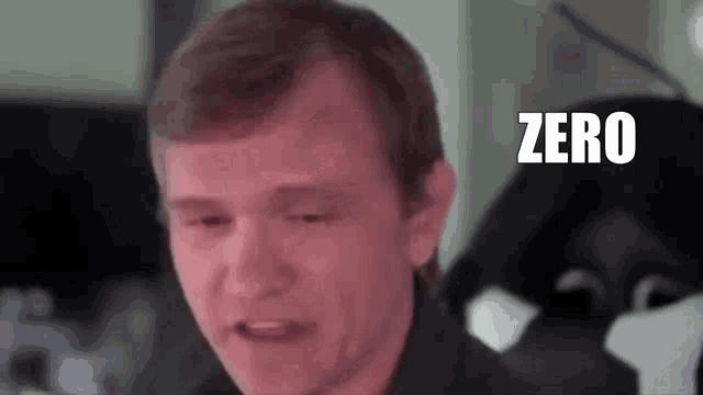 a man is making a funny face with the word zero in the background