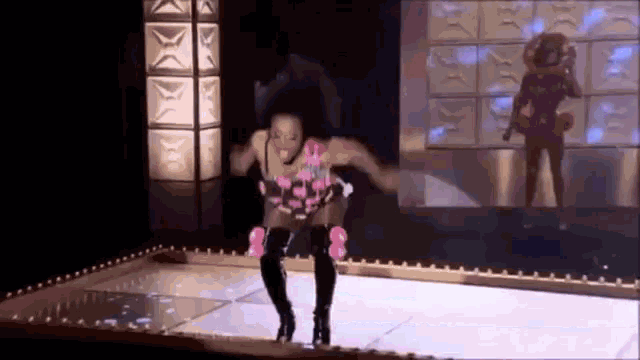 a woman is dancing on a stage in front of a mirror .